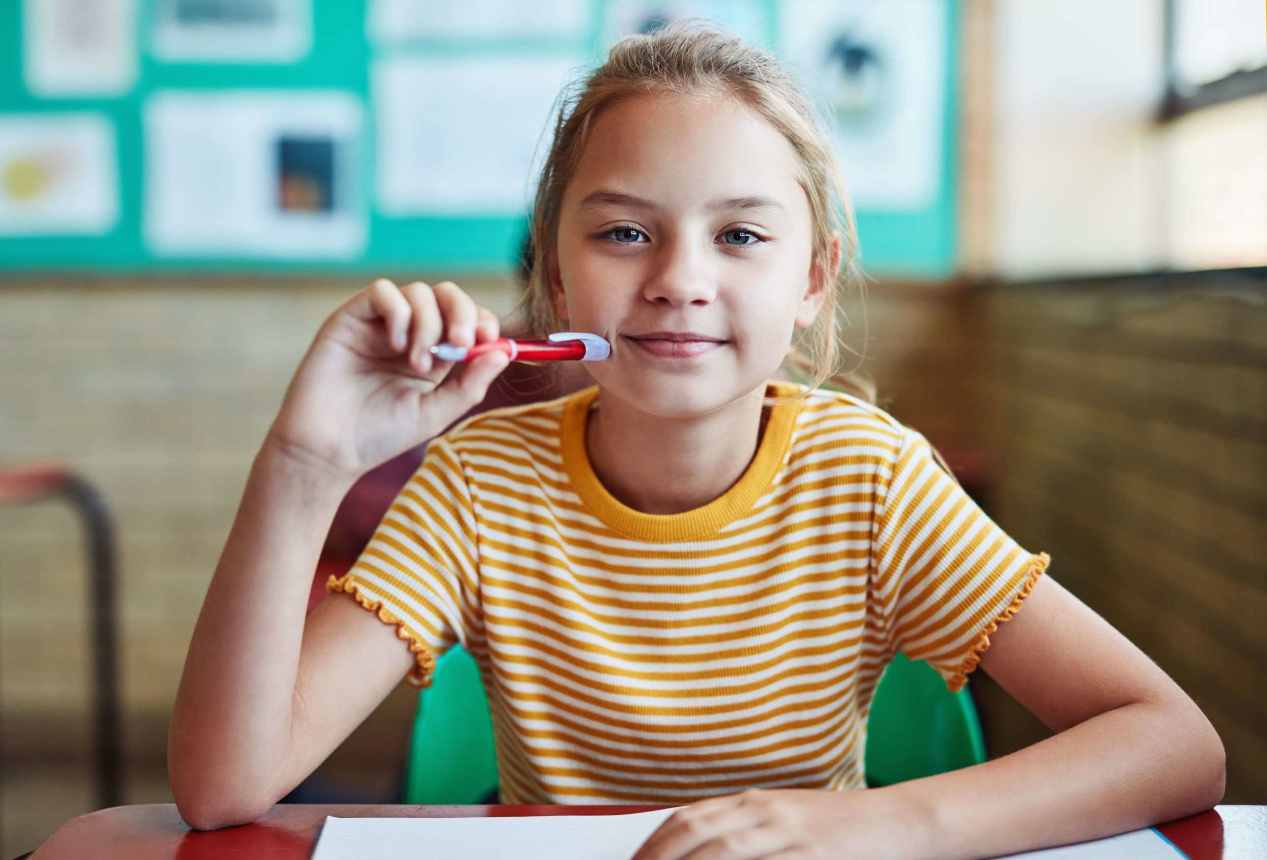 Skoleelev som sitter ved skolepulten